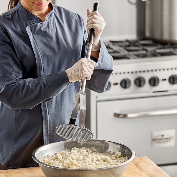 A person using a Tablecraft potato masher to mix food in a bowl.
