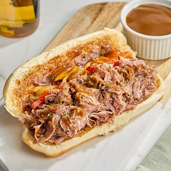 A sandwich with Vienna Beef Italian-Style Sliced Roast Beef and gravy on a white plate.