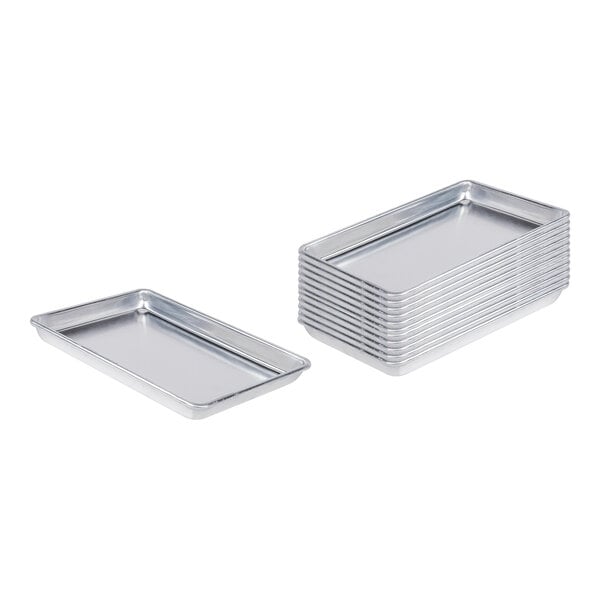 A stack of rectangular silver Choice aluminum baking trays.