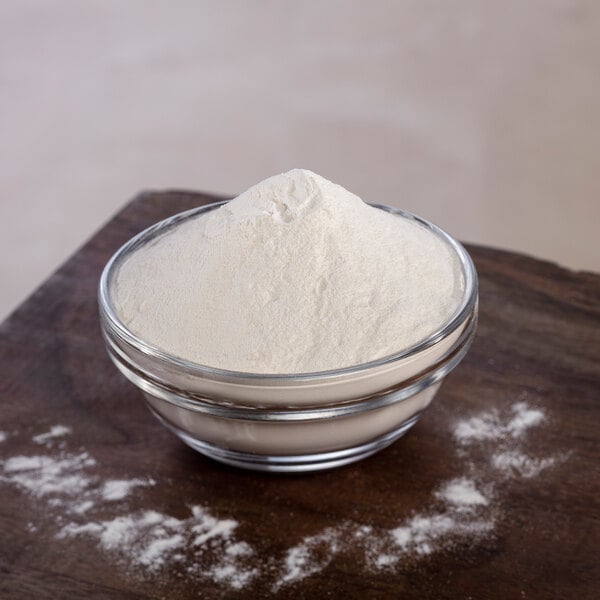 A bowl of Briess Pilsen Light Dry Malt Extract powder on a table.