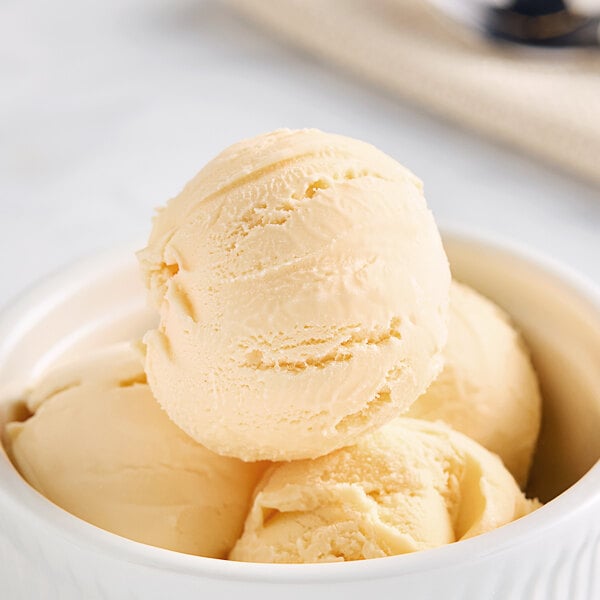 A bowl of Bravo Creamsicle Gelato with a spoon in it.