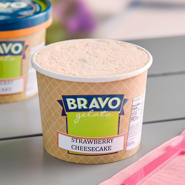 A container of Bravo Gelato Strawberry Cheesecake gelato on a table.