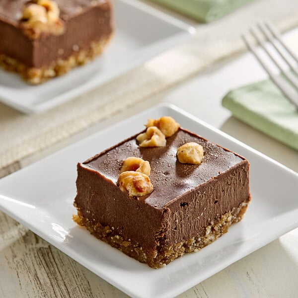 Two square brown Nats Rawline chocolate cakes with hazelnuts on top.