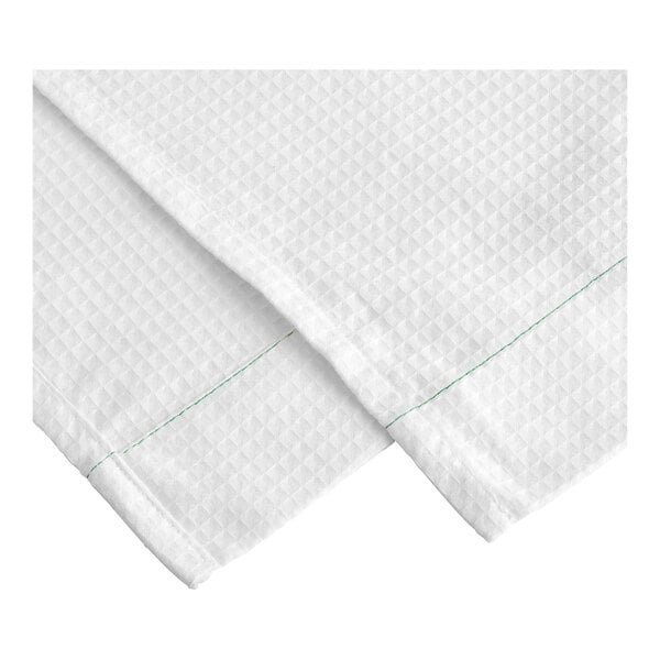 A white Adorn decorative top sheet with green stitching.