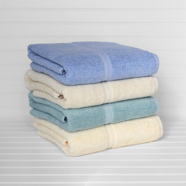 A stack of blue 1888 Mills Fibertone pool towels on a white surface.