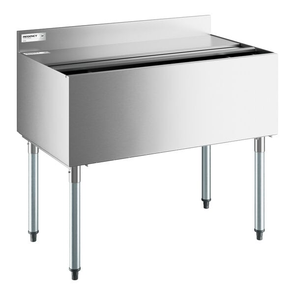 A stainless steel underbar ice bin with four legs, a sliding lid, and a backsplash.