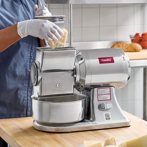 An electric hard cheese grater with a stainless steel body and a bowl for collecting grated cheese.