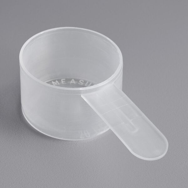 A clear plastic measuring cup with a short handle.