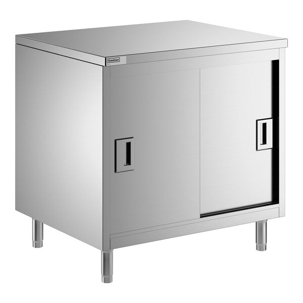 A stainless steel enclosed base table with sliding doors and a midshelf.