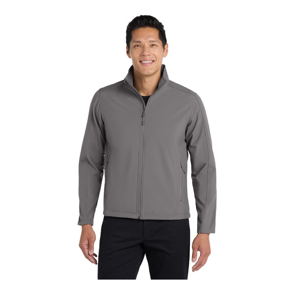 A man wearing a Port Authority deep smoke soft shell jacket.