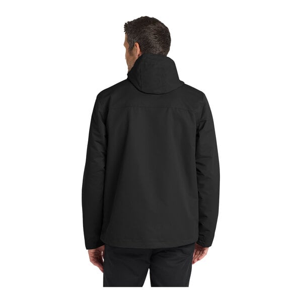 A person wearing a black Port Authority all-conditions parka jacket.