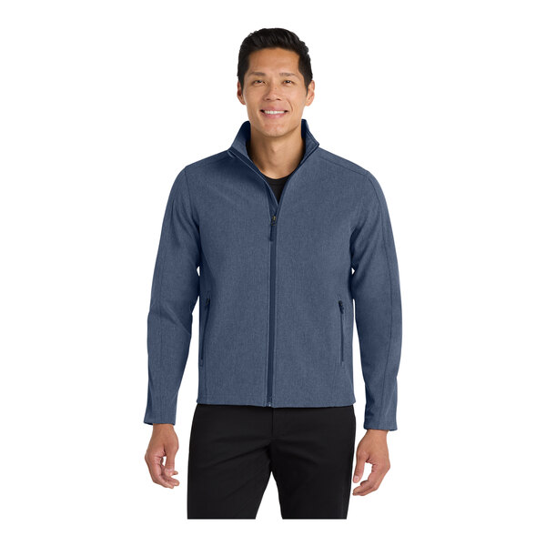 A man wearing a navy Port Authority core soft shell jacket with a white background.