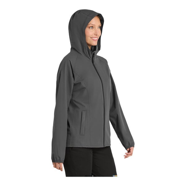 A woman wearing a grey Port Authority essential rain jacket.