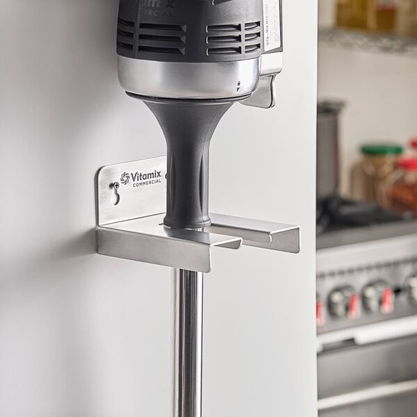 A silver and black Vitamix Immersion Blender on a metal pole.