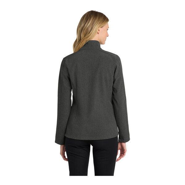 A woman wearing a black and charcoal heather Port Authority Core Soft Shell Jacket.