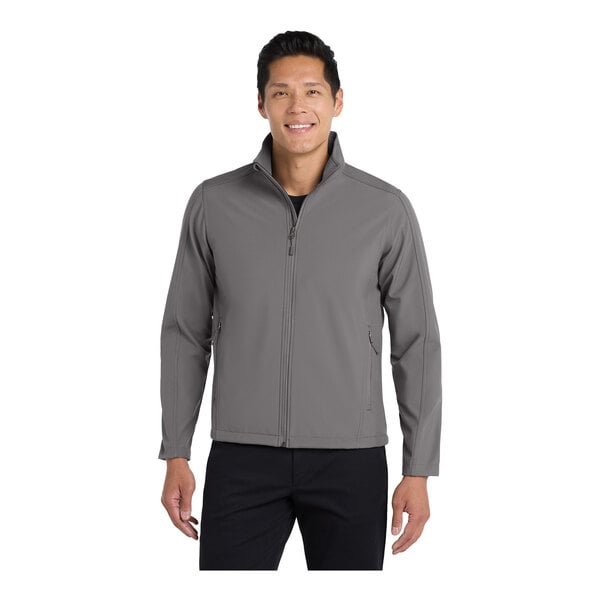 A man wearing a Port Authority deep smoke soft shell jacket.
