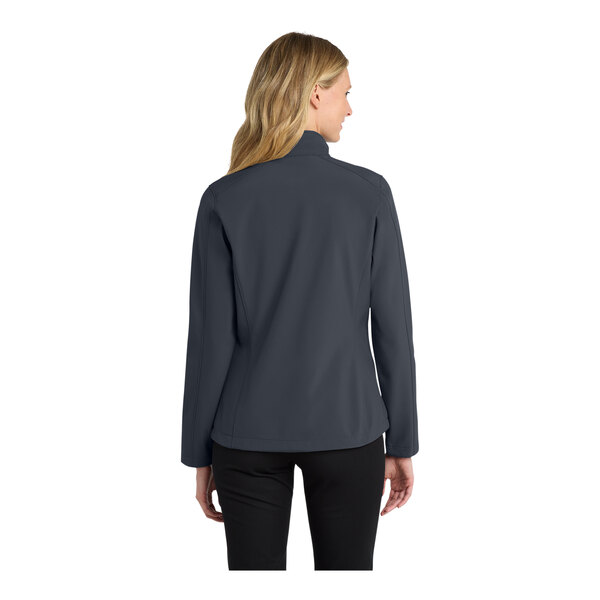 A woman wearing a Port Authority women's grey soft shell jacket.
