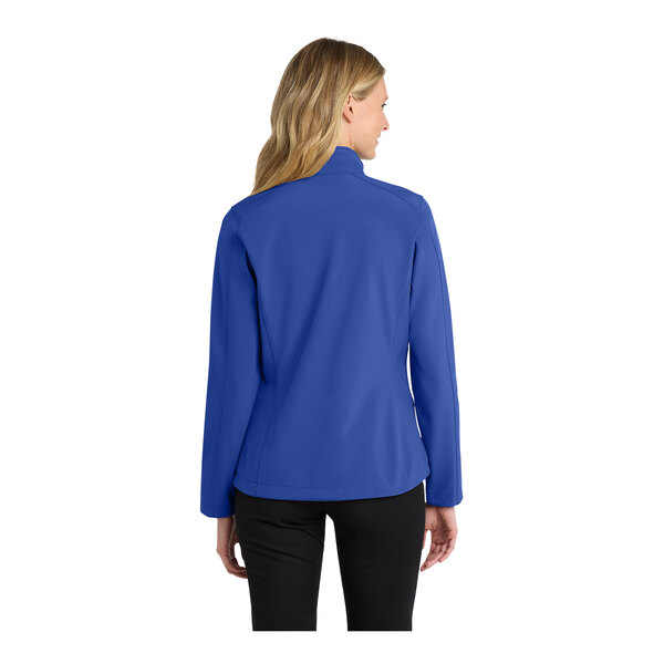 A woman wearing a Port Authority royal blue soft shell jacket.
