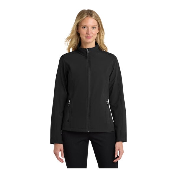 A woman wearing a black Port Authority core soft shell jacket.