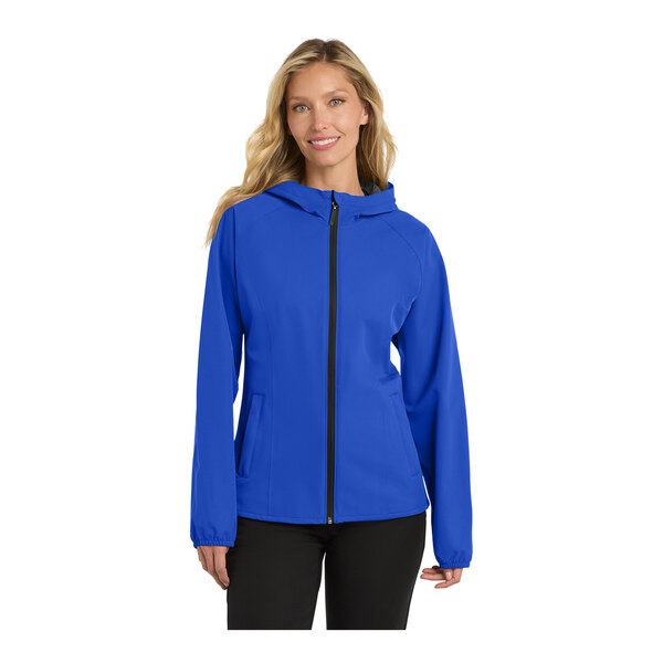 A woman wearing a blue Port Authority softshell rain jacket with a zipper.