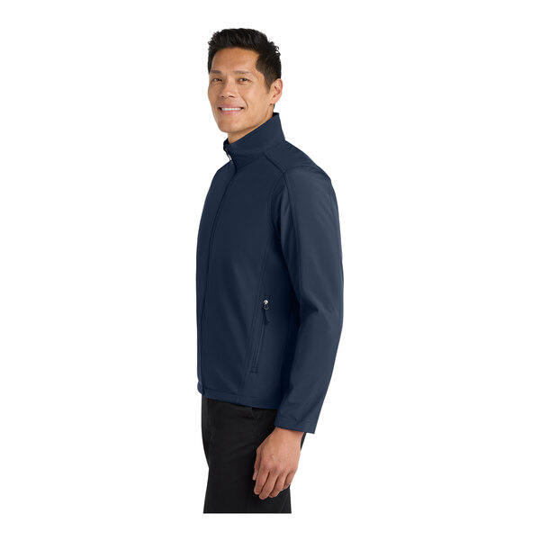 A man wearing a Port Authority dress blue core soft shell jacket.
