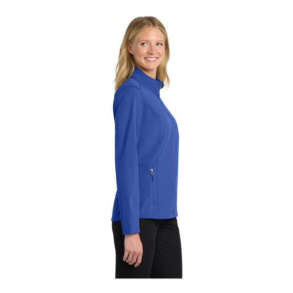 A woman wearing a blue Port Authority full-zip softshell jacket.