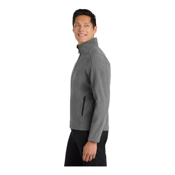 A man in a Port Authority pearl gray heather soft shell jacket.