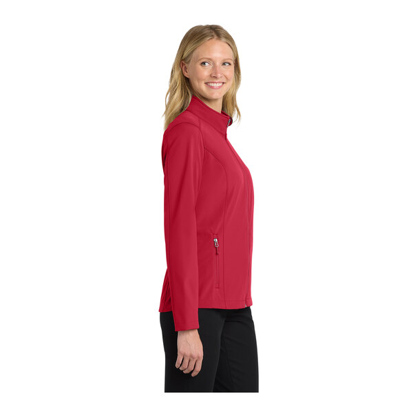 A woman wearing a red Port Authority full-zip softshell jacket.