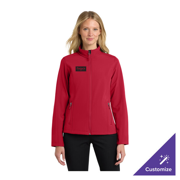 A women's rich red soft shell jacket with a front zipper and zippered pockets, shown on a model.
