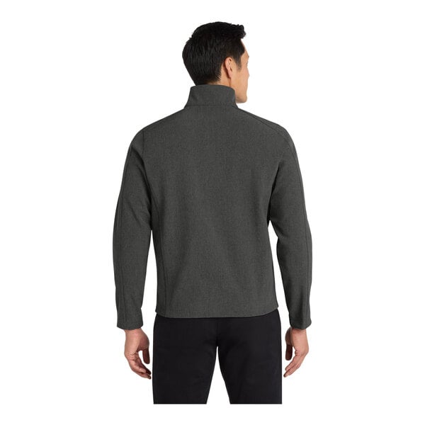 A man wearing a charcoal heather Port Authority core soft shell jacket.