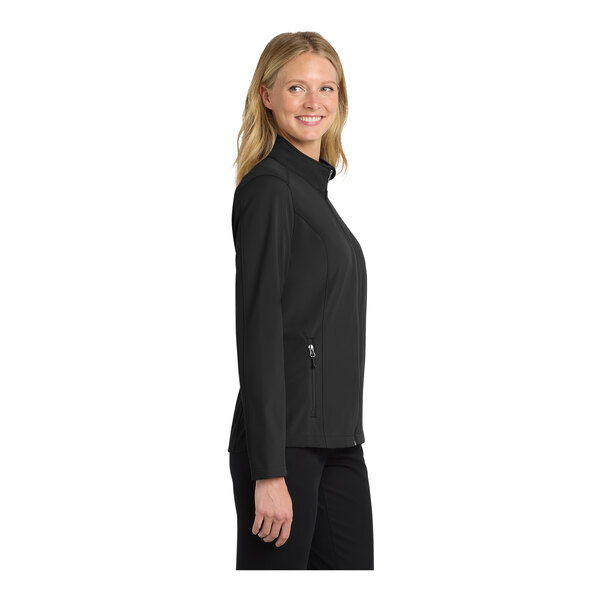 A woman wearing a black Port Authority Core Soft Shell jacket.