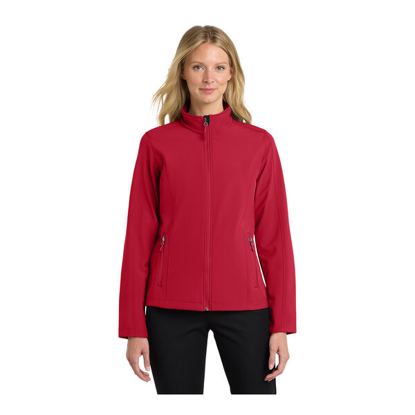 A woman wearing a red Port Authority core soft shell jacket.