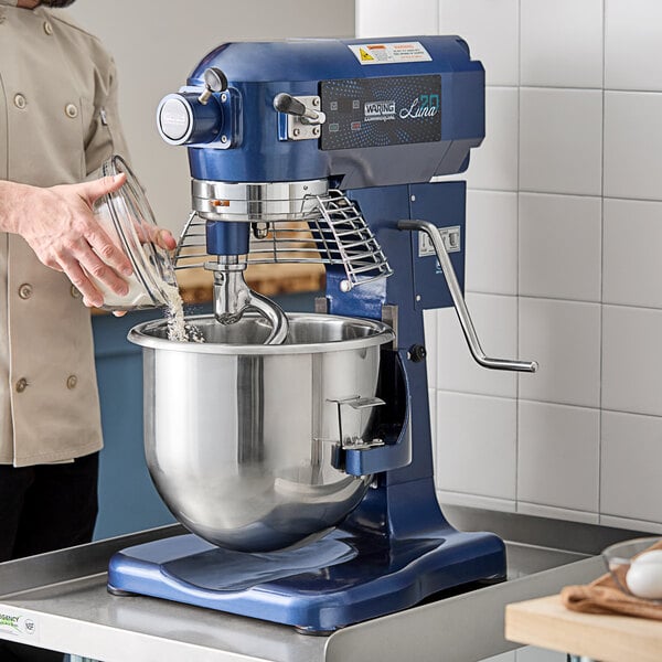 A man standing in front of a blue Waring Luna planetary stand mixer.