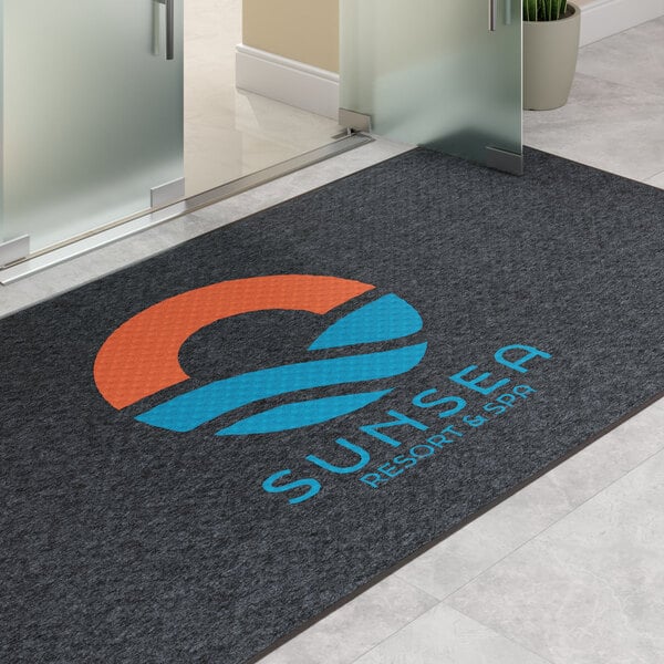 A large rectangular customizable entrance mat with a logo and text, designed for indoor or outdoor use.