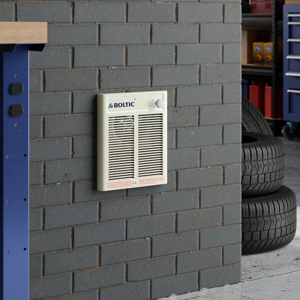 A Boltic steel electric fan-forced wall heater mounted on a gray brick wall.