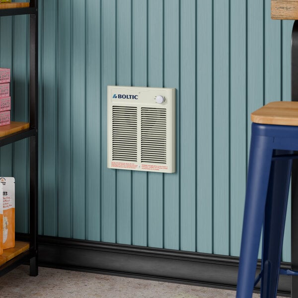 A Boltic steel electric fan-forced wall heater mounted on a blue paneled wall.