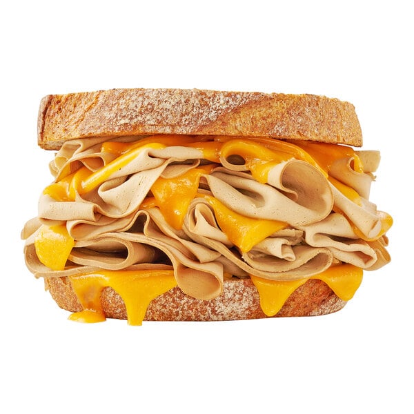 A close up of a sandwich with Prime Roots vegan smoked turkey and cheese.