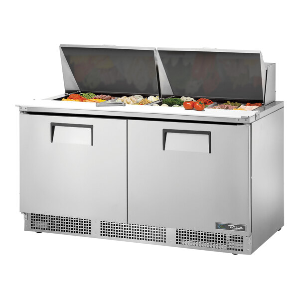 A True Mega Top Refrigerated Sandwich Prep Table with food on the counter.