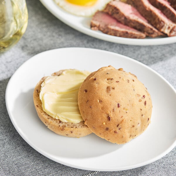 A plate of food with a dinner roll and a sandwich.