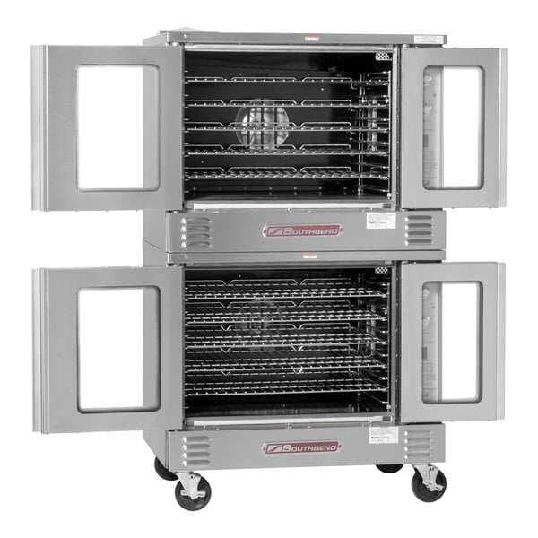 A double-deck stainless steel convection oven with glass-paneled doors, multiple wire racks, and caster wheels, shown with both oven doors open.
