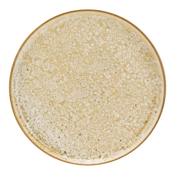 A close up of a Cosy & Trendy beige stoneware coupe plate with speckles.