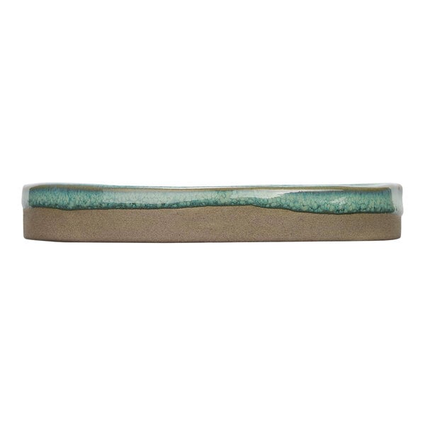 A close-up of a Cosy & Trendy Ocean Green stoneware plate with a blue and white surface.