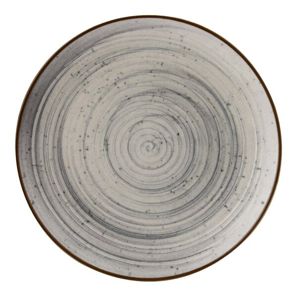 A close-up of a Cosy & Trendy Sintra dusty blue stoneware coupe plate with a spiral design in white and gray.