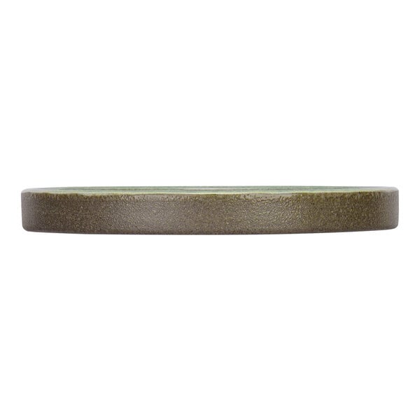 A side view of a round, flat, stoneware saucer or plate with a textured, earthy brown edge and a hint of mint green on the top surface.