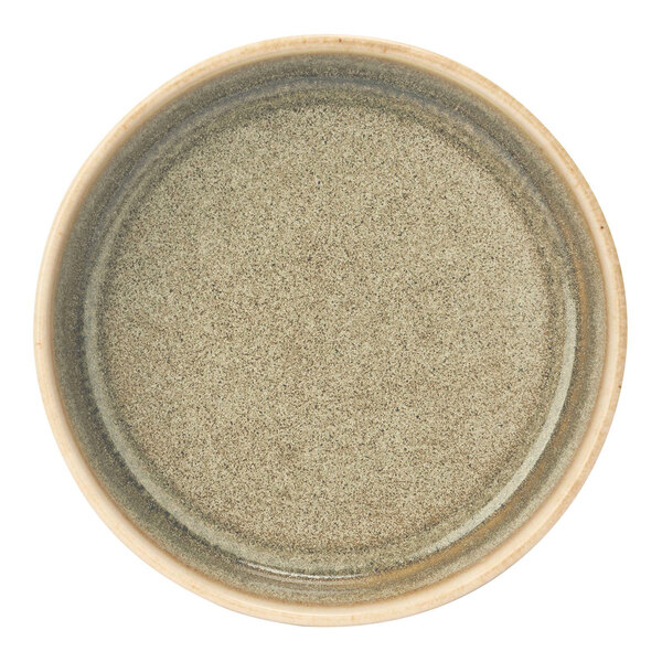 A close up of a green Cosy & Trendy porcelain deep plate with a brown rim.