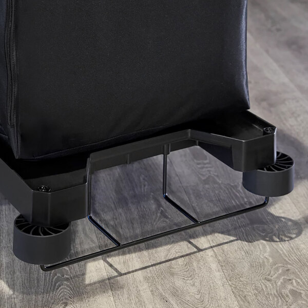 A black Rubbermaid housekeeping cart with a black bag on it.