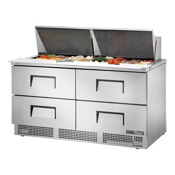 A True refrigerated sandwich prep table with food trays on top.