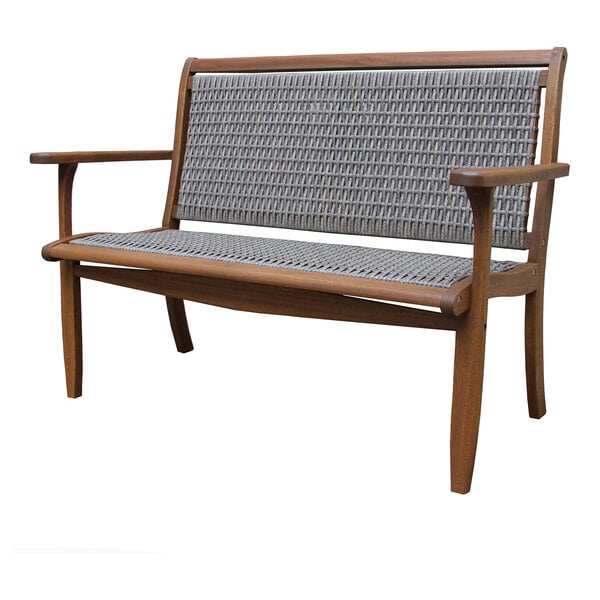 An Outdoor Interiors driftwood gray wooden bench with a wicker back.