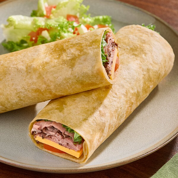 Two Celia's Chili flour tortillas filled with meat and vegetables on a plate.