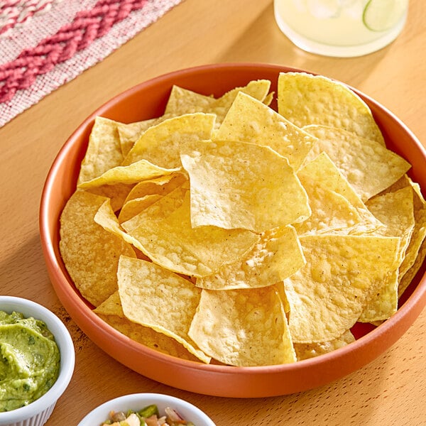 A bowl of Celia's yellow corn tortilla chips on a table.